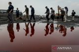 Petugas Penegakan Hukum (Gakkum) Kementerian Lingkungan Hidup berjalan di dekat genangan air limbah saat meninjau gudang pengolahan limbah di Pasar Kemis, Kabupaten Tangerang, Banten, Jumat (16/5/2025). Kementerian Lingkungan Hidup menyegel gudang yang berisi limbah Bahan Berbahaya dan Beracun (B3) tersebut karena tidak memiliki izin operasional dan adanya dugaan pelanggaran kerusakan lingkungan. ANTARA FOTO/Putra M. Akbar/gp