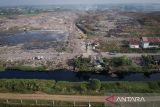 Foto udara Sungai Cirarab yang tercemar akibat lindi dari Tempat Pembuangan Akhir (TPA) Jatiwaringin di Sukadiri, Kabupaten Tangerang, Banten, Jumat (16/5/2025). Kementerian Lingkungan Hidup menyegel TPA Jatiwaringin karena dinilai menyalahi aturan pengelolaan sampah sehingga berdampak membahayakan lingkungan sekitar. ANTARA FOTO/Putra M. Akbar/gp