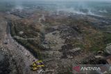Foto udara kepulan asap yang keluar dari tumpukan sampah Tempat Pembuangan Akhir (TPA) Jatiwaringin di Sukadiri, Kabupaten Tangerang, Banten, Jumat (16/5/2025). Kementerian Lingkungan Hidup menyegel TPA Jatiwaringin karena dinilai menyalahi aturan pengelolaan sampah sehingga berdampak membahayakan lingkungan sekitar. ANTARA FOTO/Putra M. Akbar/gp