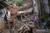 Warga membersihkan material longsor yang menimbun rumah dan jalan di Desa Wangunsari, Lembang, Kabupaten Bandung Barat, Jawa Barat, Minggu (18/5/2025). Berdasarkan data BPBD Kabupaten Bandung Barat, sebanyak 21 rumah dengan rincian empat rumah rusak berat, satu rumah rusak sedang, satu rumah rusak ringan dan 15 rumah dalam kondisi terancam terdampak bencana longsor akibat tingginya intensitas hujan yang memicu longsor tebing di dekat permukiman warga pada Jumat (16/5). ANTARA FOTO/Abdan Syakura/agr