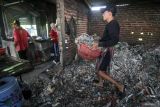 Pekerja membawa sampah plastik sebagai bahan bakar untuk menggoreng tahu di salah satu pabrik tahu  di Tropodo, Krian, Sidoarjo, Jawa Timur, Minggu (18/5/2025). Pemerintah Kabupaten Sidoarjo menawarkan penggunaan bahan bakar kayu atau gas bumi dari PGN dan akan berkoordinasi dengan Pemprov Jawa Timur untuk memberikan subsidi jika pengusaha beralih ke gas bumi dalam rangka mengurangi penggunaan sampah plastik, khususnya di industri tahu. Antara Jatim/Umarul Faruq