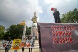 Sejumlah aktivis lingkungan membentangkan poster saat aksi damai di Alun Alun Sidoarjo, Jawa Timur, Senin (19/5/2025). Aksi komunitas ECOTON itu mengajak produsen tahu di Krian untuk tidak menggunakan sampah plastik sebagai bahan bakar dalam proses produksi tahu karena hasil pembakaran sampah plastik bisa mencemari Udara. Antara Jatim/Umarul Faruq