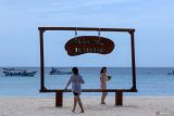 Dua wisatawan asing bermain di Pulau Tabuhan, Banyuwangi, Jawa Timur, Senin (19/5/2025). Pulau tidak berpenghuni yang terletak di tengah Selat Bali dan menjadi salah satu wisata andalan Banyuwangi itu kini kondisinya terus menyusut akibat abrasi, dari semula luasanya sekitar 8 hektar pada tahun 2010 saat ini hanya sekitar 4,5 hektar saja. ANTARA Jatim/Budi Candra Setya/mas.