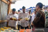 Menteri UMKM Maman Abdurrahman (tengah) bersama Kepala Badan Gizi Nasional Dadan Hindayana (kanan) dan Wakil Menteri UMKM Helvi Yuni Moraza (kiri) meninjau produk UMKM saat melakukan kunjungan ke Desa Cimekar, Cileunyi, Kabupaten Bandung, Jawa Barat, Senin (19/5/2025). Dalam kunjungannya ke Kabupaten Bandung, Menteri UMKM berkesempatan untuk menghadiri peluncuran program perdana perluasan keterlibatan UMKM dalam program makanan bergizi gratis. ANTARA FOTO/Raisan Al Farisi/agr