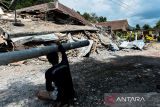 Warga berada di depan bangunan yang runtuh akibat longsor di Desa Kendan, Kecamatan Nagreg, Kabupaten Bandung, Jawa Barat, Senin (19/5/2025). Longsor yang terjadi pada Minggu 18/5 malam tersebut mengakibatkan kompleks kantor dan fasilitas desa serta satu rumah warga rusak berat dan tiga orang mengalami luka-luka. ANTARA FOTO/Raisan Al Farisi/agr