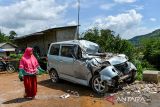 Warga melintas di samping kendaraan yang rusak akibat longsor di Desa Kendan, Kecamatan Nagreg, Kabupaten Bandung, Jawa Barat, Senin (19/5/2025). Longsor yang terjadi pada Minggu 18/5 malam tersebut mengakibatkan kompleks kantor dan fasilitas desa serta satu rumah warga rusak berat dan tiga orang mengalami luka-luka. ANTARA FOTO/Raisan Al Farisi/agr