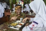 Wakil Wali Kota Tasikmalaya Diky Candra meninjau siswa menyantap Makan Bergizi Gratis (MBG) saat peluncuran dapur umum di MTs Negeri 3 Kota Tasikmalaya, Jawa Barat, Senin (19/5/2025). Badan Gizi Nasional (BGN) mencatat realisasi anggaran untuk program MBG mencapai Rp2,38 triliun atau 3,36 persen dari total pagu anggaran sebesar Rp 71 triliun pada tahun 2025. ANTARA FOTO/Adeng Bustomi/agr