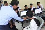 Guru mengajari calon siswa sekolah rakyat mengoperasikan komputer saat Simulasi Pembelajaran Sekolah Rakyat di Internasional Islamic Boarding School (IBBS) Al Hikmah, Batu, Jawa Timur, Senin (19/5/2025).  Simulasi tersebut diadakan untuk mengenalkan sekaligus memberi gambaran kepada calon siswa sekolah rakyat mengenai sistem pembelajaran serta kurikulum yang nantinya akan diajarkan. ANTARA Jatim/Ari Bowo Sucipto/mas.