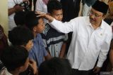 Menteri Sosial Syaifullah Yusuf (kanan) memegang kepala seorang calon siswa sekolah rakyat sebelum mengikuti Simulasi Pembelajaran Sekolah Rakyat di Internasional Islamic Boarding School (IBBS) Al Hikmah, Batu, Jawa Timur, Senin (19/5/2025).  Simulasi tersebut diadakan untuk mengenalkan sekaligus memberi gambaran kepada calon siswa sekolah rakyat mengenai sistem pembelajaran serta kurikulum yang nantinya akan diajarkan. ANTARA Jatim/Ari Bowo Sucipto/mas.