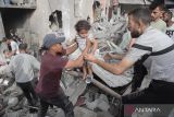 Warga menyelamatkan seorang anak usai serangan udara Israel di kamp pengungsian Jabalia, bagian utara Jalur Gaza, Minggu (18/5/2025). ANTARA FOTO/Xinhua/Abdul Rahman Salama/bar
