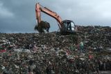 Tempat Pembuangan Akhir di Pontianak. Dua pemulung memilah sampah di bawah alat berat eskavator yang sedang meratakan tumpukan sampah di Tempat Pembuangan Akhir (TPA) Batulayang, Pontianak, Kalimantan Barat, Minggu (18/5/2025). Pemerintah Kota Pontianak mencatat TPA Batulayang yang berada di atas lahan gambut seluas 20 hektar dengan kedalaman mencapai 18 meter tersebut menampung sekitar 400 ton sampah setiap hari. ANTARA FOTO/Jessica Wuysang.