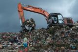 Tempat Pembuangan Akhir di Pontianak. Dua pemulung memilah sampah di bawah alat berat eskavator yang sedang meratakan tumpukan sampah di Tempat Pembuangan Akhir (TPA) Batulayang, Pontianak, Kalimantan Barat, Minggu (18/5/2025). Pemerintah Kota Pontianak mencatat TPA Batulayang yang berada di atas lahan gambut seluas 20 hektar dengan kedalaman mencapai 18 meter tersebut menampung sekitar 400 ton sampah setiap hari. ANTARA FOTO/Jessica Wuysang.