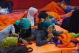 Ibu pengungsi bersama anak-cucunya rebahan di atas matras di Posko Pengngsian Desa Depok, Trenggalek, Jawa Timur, Senin (19/5/2025). Bencana banjir dan longsor menerjang sejumlah wilayah di daerah itu menyebabkan enam orang hilang diduga tertimbun longsor dan puluhan lainnya mengungsi ke tempat aman. Antara Jatim/Destyan Sujarwoko/um 