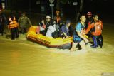 Relawan Baznas Tanggap bencana menggunakan perahu karet mengevakuasi warga yang terjebak banjir di Jalan Raya Soekarno-Hatta, Trenggalek, Jawa Timur, Selasa (20/5/2025). bencana banjir dan longsor menerjang sejumlah wilayah di daerah itu menyebabkan enam orang hilang diduga tertimbun longsor dan puluhan lainnya mengungsi ke tempat aman. Antara Jatim/Destyan Sujarwoko/um 