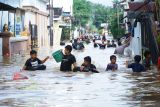 Warga bermain air jalan pemukiman yang terendam banjir di wilayah Kota Trenggalek, Jawa Timur, Selasa (20/5/2025). Hujan deras yang mengguyur wilayah tersebut dua hari terakhir menyebabkan lebih dari seribu rumah di empat kecamatan daerah itu terendam banjir bandang. Antara Jatim/Destyan Sujarwoko/um 