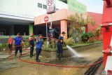 Petugas damkar menyemprotkan air untuk membersihkan sisa lumpur yang sempat masuk area layanan RSUD dr. Soedomo, Trenggalek, Jawa Timur, Selasa (20/5/2025). Hujan deras yang mengguyur wilayah tersebut dua hari terakhir menyebabkan lebih dari seribu rumah di empat kecamatan daerah itu terendam banjir bandang. Antara Jatim/Destyan Sujarwoko/um 