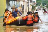 Relawan Baznas tanggap bencana menggunakan perahu karet mengevakuasi dua balita yang terjebak banjir di wilayah Kota Trenggalek, Jawa Timur, Selasa (20/5/2025). Hujan deras yang mengguyur wilayah tersebut dua hari terakhir menyebabkan lebih dari seribu rumah di empat kecamatan daerah itu terendam banjir bandang. Antara Jatim/Destyan Sujarwoko/um 
