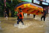 Relawan Baznas tanggap bencana menggoting perahu karet untuk membantu evakuasi warga terjebak banjir di wilayah Kota Trenggalek, Jawa Timur, Selasa (20/5/2025). Hujan deras yang mengguyur wilayah tersebut dua hari terakhir menyebabkan lebih dari seribu rumah di empat kecamatan daerah itu terendam banjir bandang. Antara Jatim/Destyan Sujarwoko/um 