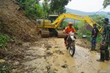 Petugas BPBD melintasi salah satu titik longsor yang telah berhasil dibuka menggunakan alat berat di Desa Depok, Trenggalek, Jawa Timur, Selasa (20/5/2025). BPBD setempat mengerahkan tiga alat berat untuk membantu proses normalisasi jalur menuju titik utama dimana ada 10 rumah warga terdampak dan enam warga dilaporkan hilang diduga tertimbun longsor. Antara Jatim/Destyan Sujarwoko/um 