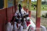Sejumlah murid mengikuti kegiatan belajar mengajar di teras ruang kelas SD Negeri Bojen 2, Sobang, Pandeglang, Banten, Selasa (20/5/2025). Pihak sekolah mengatakan, selama tiga tahun terakhir murid kelas tiga A dan B terpaksa mengikuti kegiatan belajar di teras sekolah secara bergantian setiap minggunya, sementara untuk murid kelas satu dan dua diterapkan sistem masuk bergantian pada pagi dan siang karena kekurangan ruang kelas. ANTARA FOTO/Angga Budhiyanto/gp