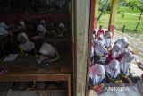 Sejumlah murid mengikuti kegiatan belajar mengajar di teras ruang kelas SD Negeri Bojen 2, Sobang, Pandeglang, Banten, Selasa (20/5/2025). Pihak sekolah mengatakan, selama tiga tahun terakhir murid kelas tiga A dan B terpaksa mengikuti kegiatan belajar di teras sekolah secara bergantian setiap minggunya, sementara untuk murid kelas satu dan dua diterapkan sistem masuk bergantian pada pagi dan siang karena kekurangan ruang kelas. ANTARA FOTO/Angga Budhiyanto/gp