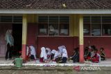 Sejumlah murid mengikuti kegiatan belajar mengajar di teras ruang kelas SD Negeri Bojen 2, Sobang, Pandeglang, Banten, Selasa (20/5/2025). Pihak sekolah mengatakan, selama tiga tahun terakhir murid kelas tiga A dan B terpaksa mengikuti kegiatan belajar di teras sekolah secara bergantian setiap minggunya, sementara untuk murid kelas satu dan dua diterapkan sistem masuk bergantian pada pagi dan siang karena kekurangan ruang kelas. ANTARA FOTO/Angga Budhiyanto/gp