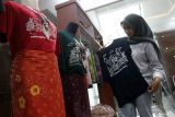 Pengunjung melihat produk kerajinan yang dipajang di Pojok Usaha Mikro Kecil Menengah (UMKM) di Gedung DPRD Kota Malang, Jawa Timur, Jawa Timur, Selasa (20/5/2025). Pemerintah berupaya menjaga laju pertumbuhan ekonomi di sektor UMKM dengan memperluas pasar ekspor, menggenjot akselerasi digitalisasi UMKM maupun sektor publik dan mendorong peningkatan produktivitas serta daya saing melalui fasilitas pembiayaan bagi UMKM dan Koperasi. ANTARA Jatim/Ari Bowo Sucipto/mas.