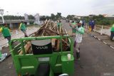 Petugas menata bambu dan kayu yang diambil dari kaki Jembata Lama Kediri (Brug Over Den Brantas te Kediri) di Kota Kediri, Jawa Timur, Selasa (20/5/2025). Pembersihan jembatan cagar budaya berkonstruksi besi pertama di Jawa tersebut dilakukan setelah pladu (flushing atau penggelontoran) bendungan Wlingi dan Lodoyo Blitar yang membawa rumpun bambu bercampur sampah tersangku pada kaki jembatan dan berpotensi merusak konstruksi seiring meningkatnya kembali volume air saat musim hujan. Antara Jatim/Prasetia Fauzani/um