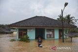 Warga terendam banjir di halaman Puskesmas Pembantu di Sukaresik, Kabupaten Tasikmalaya, Jawa Barat, Rabu (21/5/2025). Hujan deras yang mengguyur wilayah Kabupaten Tasikmalaya pada Selasa (20/5) malam, menyebabkan Sungai Citanduy dan Cikidang meluap dan menyebabkan 1.011 rumah warga terendam banjir dengan ketinggian 60 cm hingga dua meter serta menewaskan seorang lansia akibat tenggelam saat menjaring ikan. ANTARA FOTO/Adeng Bustomi/agr