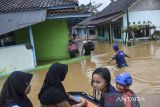 Anggota Tagana dan BPBD Kabupaten Tasikmalaya menggunakan perahu karet mengevakuasi korban banjir di Sukaresik, Kabupaten Tasikmalaya, Jawa Barat, Rabu (21/5/2025). Hujan deras yang mengguyur wilayah Kabupaten Tasikmalaya pada Selasa (20/5) malam, menyebabkan Sungai Citanduy dan Cikidang meluap dan menyebabkan 1.011 rumah warga terendam banjir dengan ketinggian 60 cm hingga dua meter serta menewaskan seorang lansia akibat tenggelam saat menjaring ikan. ANTARA FOTO/Adeng Bustomi/agr