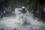 Pengendara sepeda motor menerobos banjir di Cipondoh, Kota Tangerang, Banten, Rabu (21/5/2025). Banjir setinggi 40 cm akibat tingginya intensitas hujan dan buruknya kualitas drainase tersebut membuat arus lalu lintas tersendat. ANTARA FOTO/Putra M. Akbar/gp