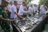 Sejumlah petugas gabungan menghancurkan gawai saat pemusnahan barang bukti di halaman Markas Kanwil Ditjenpas Jawa Timur, Medaeng, Sidoarjo, Jawa Timur, Rabu (21/5/2025). Kantor Wilayah Direktorat Jenderal Pemasyarakatan (Ditjenpas) Jawa Timur memusnahkan 280 handphone milik narapidana dan tahanan hasil penggeledahan di 39 lapas dan rutan di Jawa Timur sejak Januari hingga Mei 2025. Antara Jatim/Umarul Faruq