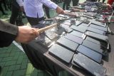 Petugas menghancurkan gawai saat pemusnahan barang bukti di halaman Markas Kanwil Ditjenpas Jawa Timur, Medaeng, Sidoarjo, Jawa Timur, Rabu (21/5/2025). Kantor Wilayah Direktorat Jenderal Pemasyarakatan (Ditjenpas) Jawa Timur memusnahkan 280 handphone milik narapidana dan tahanan hasil penggeledahan di 39 lapas dan rutan di Jawa Timur sejak Januari hingga Mei 2025. Antara Jatim/Umarul Faruq