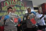 Kabid Humas Polda Bengkulu Kombes Pol Andy Pramudya Wardana (tengah) menunjukkan barang bukti senjata api rakitan saat rilis hasil operasi Penyakit Masyarakat (Pekat) Nala Premanisme di kantor Kepolisian Daerah (Polda) Bengkulu, Selasa (20/5/2025). Polda Bengkulu berhasil mengamankan 56 tersangka dari beberapa kasus seperti premanisme, pemerasan, pengancaman, pungutan liar (pungli), penimbunan bahan bakar minyak (BBM), hingga peredaran minuman keras ilegal sekaligus menyita puluhan barang bukti di antaranya satu pucuk senjata api rakitan dan 10 butir peluru aktif selama 15 hari pelaksanaan mulai 1-15 Mei 2025. ANTARA FOTO/Muhammad Izfaldi/rwa.