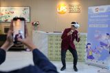 Salah satu peserta mencoba menggunakan alat bernama Sarana Optimalisasi Belajar dan Adaptasi dengan Teknologi Virtual Reality (SOBAT-VR) saat sosialisasi peran dan tugas Lembaga Penjamin  Simpanan (LPS) menggunakan teknologi VR di Surabaya, Jawa Timur, Rabu (21/5/2025). Kegiatan yang dihadiri mahasiswa, dosen dan akademisi lainnya tersebut guna memberikan pemahaman yang lebih interaktif kepada masyarakat maupun pegawai akan peran dan tugas LPS seperti proses likuidasi bank, mengamankan aset bank hingga bagaimana langkah-langkah dalam penyelamatan sistem keuangan sesuai kewenangan LPS. ANTARA Jatim/Moch Asim.