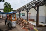 Pedagang baso tahu melintas di lokasi pembangunan sekolah rakyat di Pajajaran, Bandung, Jawa Barat, Kamis (22/5/2025). Pemerintah mencanangkan program sekolah rakyat yang dirancang untuk mengatasi persoalan anak putus sekolah melalui pendekatan sosial serta membebaskan biaya pendidikan di 100 lokasi di Indonesia dan ditargetkan dapat beroperasi pada akhir tahun 2025 dengan daya tampung maksimal 1.000 siswa per lokasi. ANTARA FOTO/Raisan Al Farisi/agr