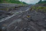 Warga melintasi kawasan rawan banjir lahar hujan Semeru di Pronojiwo, Lumajang, Jawa Timur, Kamis (22/5/2025). Badan Meteorologi, Klimatologi, dan Geofisika (BMKG) mengimbau masyarakat akan potensi cuaca ekstrem yang diperkirakan terjadi di wilayah Jatim pada periode 18â27 Mei 2025 dipengaruhi oleh dinamika atmosfer berupa gelombang Madden-Julian Oscillation (MJO) dan gelombang Low yang memperkuat pembentukan awan hujan dan dapat menimbulkan potensi bencana hidrometeorologi, seperti banjir, tanah longsor, hingga pohon tumbang. ANTARA Jatim/Irfan Sumanjaya/mas.