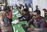 Pegawai Kementerian Agama Kota Tasikmalaya melayani pasangan pengantin saat sidang isbat nikah terpadu di Balai Kota Tasikmalaya, Jawa Barat, Kamis (22/5/2025). Pemkot Tasikmalaya bekerja sama dengan Pengadilan Agama dan Kementerian Agama menggelar sidang isbat nikah terpadu gratis yang diikuti 133 pasangan untuk membantu masyarakat mendapatkan legalitas dan administrasi pernikahan sesuai dengan ketentuan yang berlaku. ANTARA FOTO/Adeng Bustomi/agr