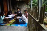Lima siswa mengerjakan soal dalam rangkaian ujian sekolah di rumah warga Desa Depok, Trenggalek, Jawa Timur, Kamis (22/5/2025). Kelima siswa terpaksa mengikuti ujian sekolah di kelas darurat karena akses jalan menuju sekolah mereka yang berjarak satu kilometer terputus terdampak longsor. ANTARA FOTO/Destyan Sujarwoko/mas.