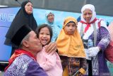 Seorang jamaah calon haji mencium pipi cucunya sebelum diberangkatkan menuju Asrama Haji Sukolilo Surabaya, Jawa Timur di Terminal Ubung, Denpasar, Bali, Rabu (21/5/2025). Kanwil Kementerian Agama Provinsi Bali mencatat jumlah jamaah calon haji dari Bali yang dijadwalkan berangkat ke Tanah Suci Makkah pada Jumat (23/5) yakni sebanyak 672 orang. ANTARA FOTO/Nyoman Hendra Wibowo/wsj.