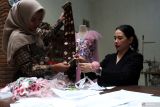 Desainer Yusi Purwanti (kanan) bersama pekerjanya memilih bahan kain songket saat merancang busana di rumah mode The Mantra, Kebonagung, Malang, Jawa Timur, Jumat (23/5/2025). Menurut pelaku industri fesyen tersebut karya busana bergaya etnik glamour dengan perpaduan sentuhan unsur budaya Indonesia seperti wayang, songket serta batik digemari pelanggannya di dalam negeri maupun mancanegara dengan rata-rata penjualan per bulan mencapai 30 potong dan dijual dengan harga jual Rp1,2 juta hingga Rp15 juta per potong menurut kualitas. ANTARA Jatim/Ari Bowo Sucipto/mas.
