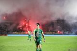 Pesepak bola Persebaya Surabaya Bruno Moreira Soares berjalan saat suporter menyalakan flare pada pertandingan Liga 1 melawan Bali United di Stadion Gelora Bung Tomo, Surabaya, Jawa Timur, Jumat (23/5/2025). Bali United mengalahkan tuan rumah Persebaya Surabaya dengan skor 3-1. Antara Jatim/Rizal Hanafi/um