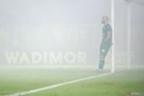 Pesepak bola Persebaya Surabaya Mohammed Rashid bersandar di tiang gawang saat suporter menyalakan flare pada pertandingan Liga 1 melawan Bali United di Stadion Gelora Bung Tomo, Surabaya, Jawa Timur, Jumat (23/5/2025). Bali United mengalahkan tuan rumah Persebaya Surabaya dengan skor 3-1. Antara Jatim/Rizal Hanafi/um
