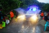 Petugas menyemprotkan desinfektan ke kendaraan, pengendara dan penumpang yang terlibat dalam operasi SAR gabungan dalam pencarian korban longsor di Dusun Kebonagung, Desa Depok, Trenggalek, Jawa Timur, Jumat (23/5/2025). Sterilisasi itu diberlakukan untuk memastikan kebersihan, higienitas serta kesehatan para petugas maupun warga yang terlibat dalam operasi SAR. Antara Jatim/Destyan Sujarwoko/um