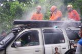 Petugas menyemprotkan desinfektan ke kendaraan, pengendara dan penumpang yang terlibat dalam operasi SAR gabungan dalam pencarian korban longsor di Dusun Kebonagung, Desa Depok, Trenggalek, Jawa Timur, Jumat (23/5/2025). Sterilisasi itu diberlakukan untuk memastikan kebersihan, higienitas serta kesehatan para petugas maupun warga yang terlibat dalam operasi SAR. Antara Jatim/Destyan Sujarwoko/um