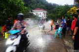 Petugas menyemprotkan desinfektan ke kendaraan, pengendara dan penumpang yang terlibat dalam operasi SAR gabungan dalam pencarian korban longsor di Dusun Kebonagung, Desa Depok, Trenggalek, Jawa Timur, Jumat (23/5/2025). Sterilisasi itu diberlakukan untuk memastikan kebersihan, higienitas serta kesehatan para petugas maupun warga yang terlibat dalam operasi SAR. Antara Jatim/Destyan Sujarwoko/um