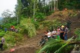Warga menonton proses pencarian korban longsor di Dusun Kebonagung, Desa Depok, Trenggalek, Jawa Timur, Jumat (23/5/2025). Operasi pencarian pada hari kelima ini belum berhasil menemukan empat dari enam korban longsor karena kendala cuaca, luasnya area longsor serta banyaknya material tanah bercampur batu dan reruntuhan bangunan. Antara Jatim/Destyan Sujarwoko/um