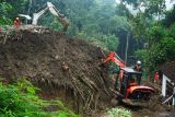 Petugas SAR gabungan mengoperasikan dua alat berat jenis eksavator untuk mencari korban longsor di Dusun Kebonagung, Desa Depok, Trenggalek, Jawa Timur, Jumat (23/5/2025). Operasi pencarian pada hari kelima ini belum berhasil menemukan empat dari enam korban longsor karena kendala cuaca, luasnya area longsor serta banyaknya material tanah bercampur batu dan reruntuhan bangunan. Antara Jatim/Destyan Sujarwoko/um