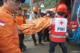 SAR gabungan memindahkan jenazah korban longsor dari ambulans SAR ke ambulans milik dinas kesehatan di depan Posko SAR gabungan di Desa Depok, Trenggalek, Jawa Timur, Sabtu (24/5/2025). Empat korban longsor berhasil dievakuasi sehingga total  enam korban seluruhnya telah ditemukan selama enam hari operasi pencarian di titik longsor utama. ANTARA Jatim/Destyan Sujarwoko/mas.