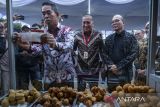 Deputi Bidang Usaha Mikro Kementerian Usaha Mikro Kecil dan Menengah (UMKM) Riza Damanik (kanan) menyaksikan Direktur Utama Asuransi Kredit Indonesia (Askrindo) M Fankar Umran (kiri) didampingi Corporate Affairs Director Alfamart Solihin (tengah) memasang stiker pelindungan asuransi pada gerobak pelaku UMKM di Alam Sutera, Kota Tangerang, Banten, Senin (26/5/2025). Askrindo bersama Alfamart meluncurkan program pelindungan usaha bagi 10.000 mitra UMKM dengan total pertanggungan Rp50 miliar untuk mengantisipasi resiko kecelakaan kerja dan kebakaran yang menjadi penghambat jalannya operasional pelaku UMKM. ANTARA FOTO/Putra M. Akbar/gp